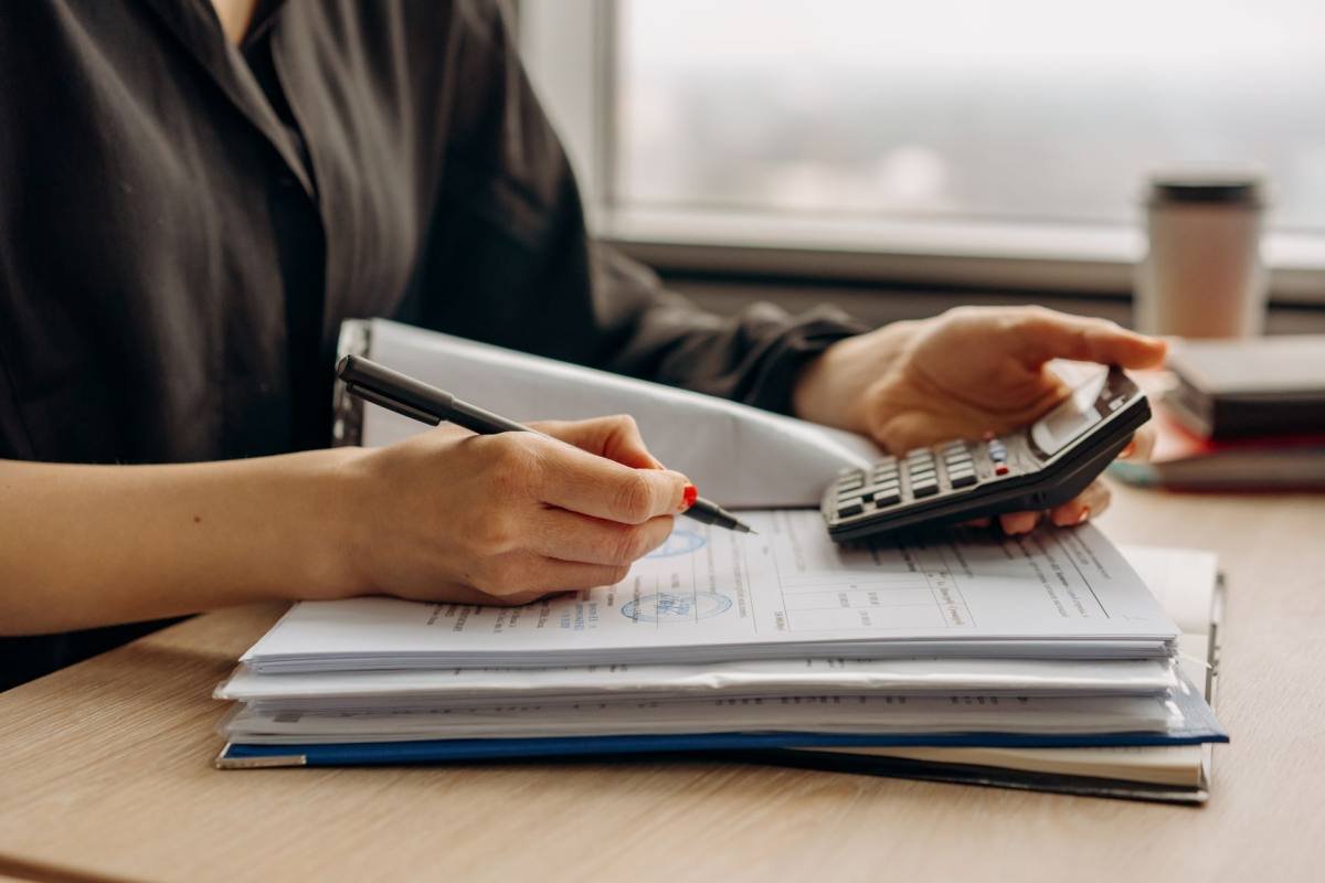 A person using a calculator with paperwork